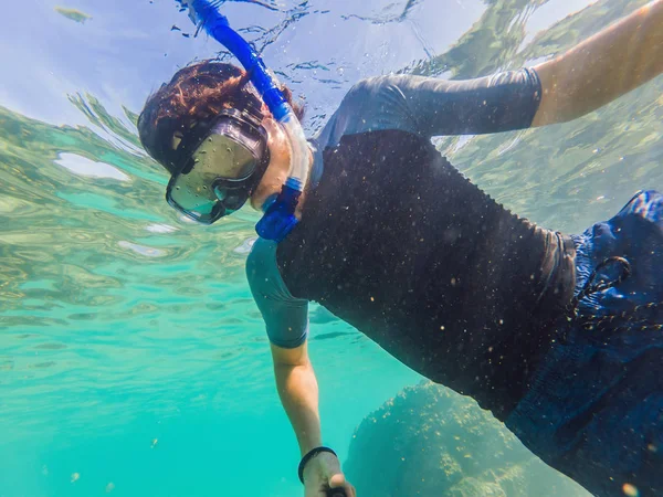 Unga män snorkling utforska undervattens korall rev landskap bakgrund i det djupa blå havet med färgglada fiskar och marint liv — Stockfoto