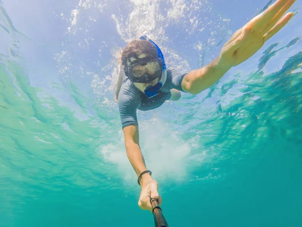 Unga män snorkling utforska undervattens korall rev landskap bakgrund i det djupa blå havet med färgglada fiskar och marint liv — Stockfoto