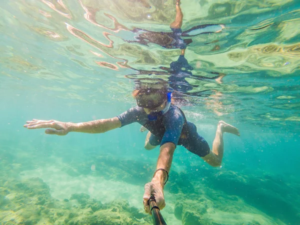 Unga män snorkling utforska undervattens korall rev landskap bakgrund i det djupa blå havet med färgglada fiskar och marint liv — Stockfoto