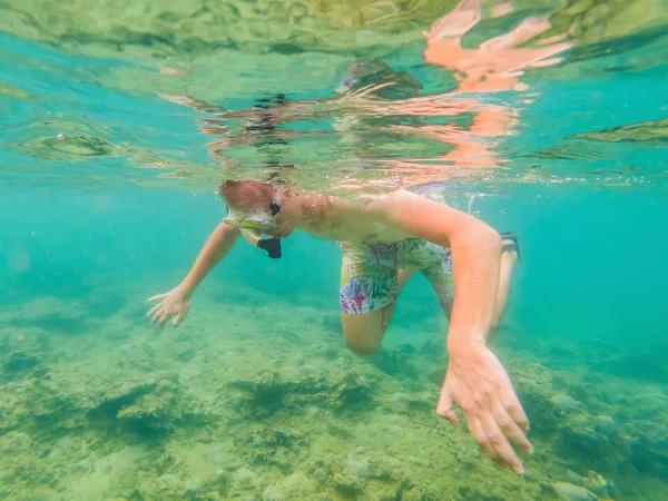 Homens jovens snorkeling explorando fundo paisagem recife de coral subaquático no oceano azul profundo com peixes coloridos e vida marinha — Fotografia de Stock