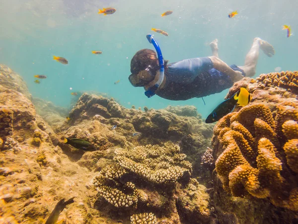 Homens jovens snorkeling explorando fundo paisagem recife de coral subaquático no oceano azul profundo com peixes coloridos e vida marinha — Fotografia de Stock