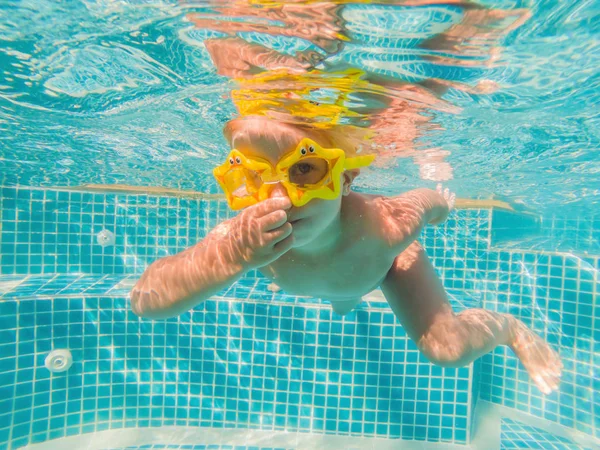 Kleines Mädchen schwimmt geschickt unter Wasser in Pool — Stockfoto