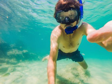 Genç erkekler renkli balık ve deniz yaşamı ile derin mavi okyanusta Sualtı mercan resifi peyzaj arka plan keşfetmek şnorkelli yüzme