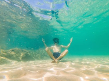 Denizde su altında yoga pozisyonunda insan sualtı portresi