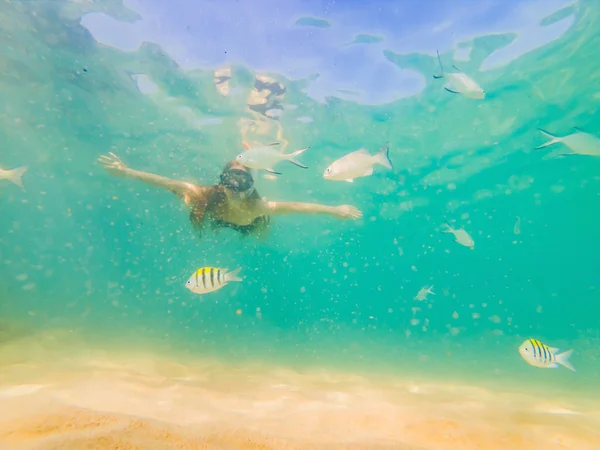 Glückliche junge Frau schwimmt im tropischen Ozean — Stockfoto