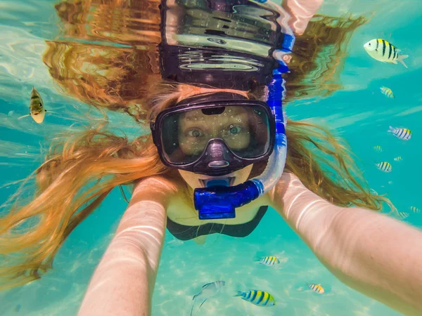 Happy young woman swimming underwater in the tropical ocean — Stock Photo, Image