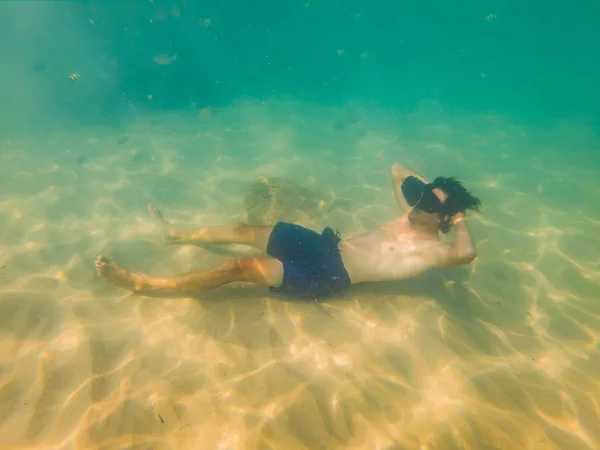 Un hombre con gafas de realidad virtual yace en el fondo del mar y observa peces. Concepto de realidad virtual —  Fotos de Stock