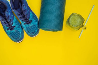 Spor turkuaz, sarı bir arka plan ve ıspanak smoothies üzerinde mavi tonları için her şey. Yoga mat, spor ayakkabı spor giyim ve su şişesi. Kavram sağlıklı yaşam tarzı, spor ve diyet. Spor