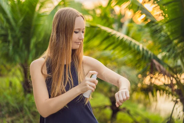 Donna che spruzza repellente per insetti sulla pelle all'aperto — Foto Stock