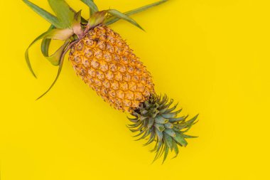 Sarı arka planda ananas. Yaz kavramı. Düz yatış, üst görünüm