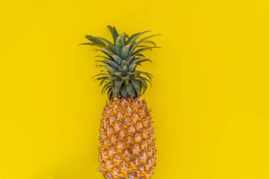 Sarı arka planda ananas. Yaz kavramı. Düz yatış, üst görünüm