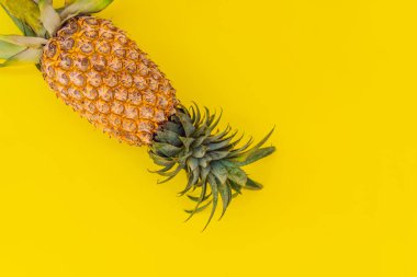 Sarı arka planda ananas. Yaz kavramı. Düz yatış, üst görünüm
