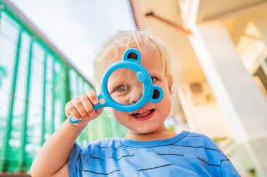 Çocuk bir büyüteç Bahçe arka planı arıyorum. Evde eğitim