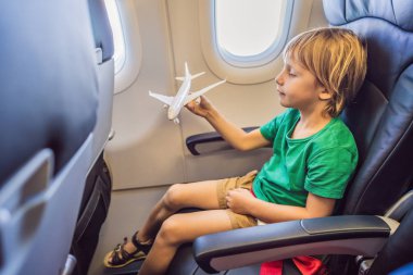 Küçük çocuk tatilde uçan ticari jet uçağı oyuncak uçak ile oynamak