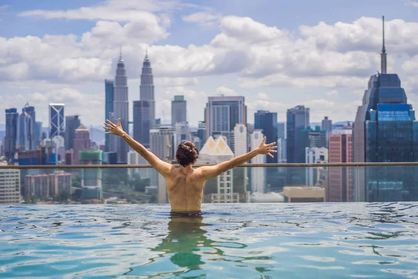 Hombre relajarse en la piscina al amanecer, en la azotea de la ciudad. Gente rica — Foto de Stock