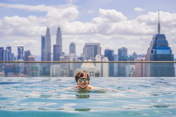 Hombre relajarse en la piscina al amanecer, en la azotea de la ciudad. Gente rica — Foto de Stock