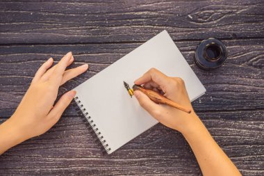 Womens hands in a wooden background holding a signboard, drawing block, paper, mockup