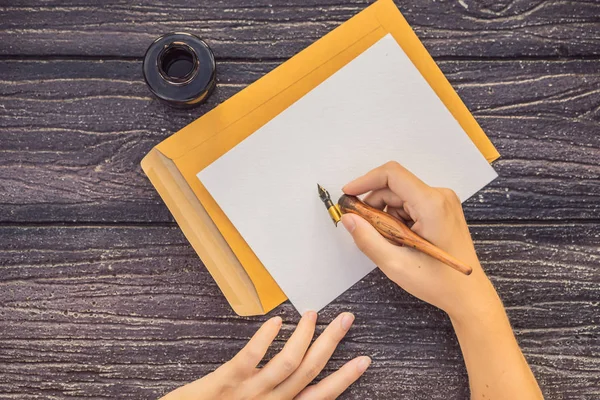 Manos de mujer en un fondo de madera sosteniendo un letrero, bloque de dibujo, papel, maqueta —  Fotos de Stock