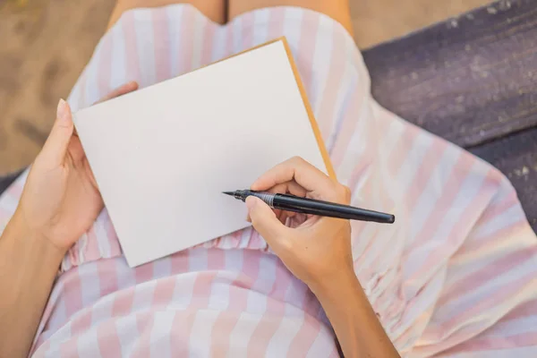 Manos de mujer en un fondo tropical sosteniendo un papel de letrero, maqueta — Foto de Stock