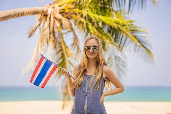 Happy woman having fun at the beach with Thailand flag. Beautiful girl enjoying travel to Asia — Stockfoto