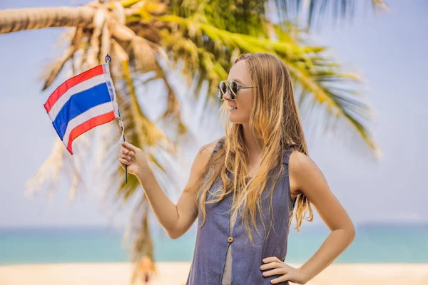 Mulher feliz se divertindo na praia com a bandeira da Tailândia. Menina bonita que gosta de viajar para a Ásia — Fotografia de Stock