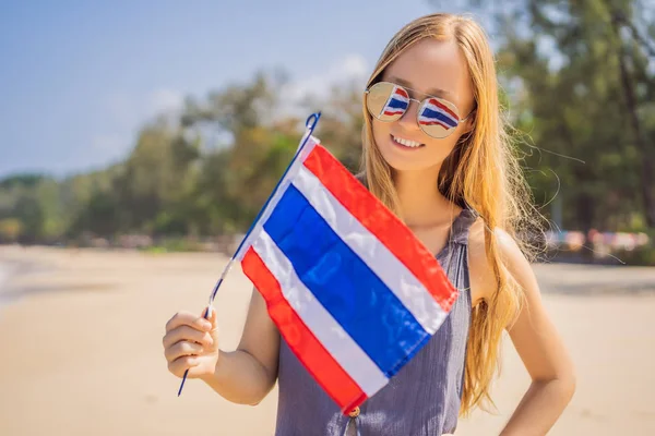 Mulher feliz se divertindo na praia com a bandeira da Tailândia. Menina bonita que gosta de viajar para a Ásia — Fotografia de Stock