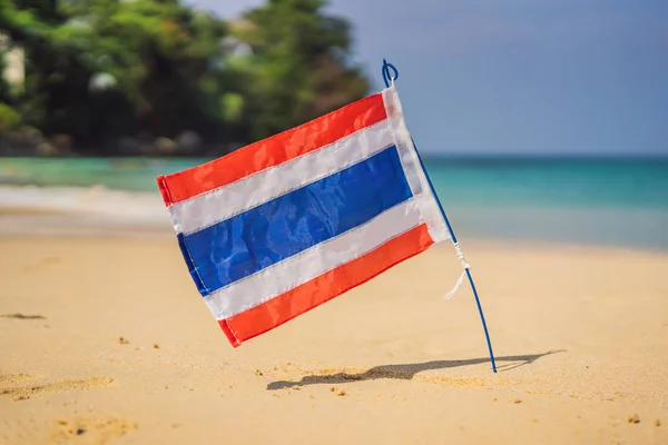 Ожидание флага Таиланда на солнечном голубом небе на фоне летнего пляжа. Тема отпуска, праздничная концепция — стоковое фото