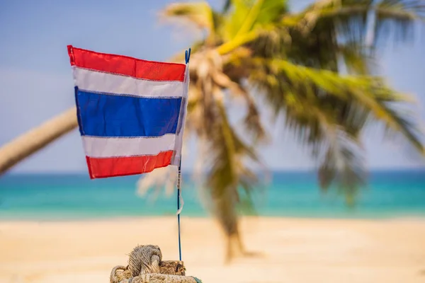 Mával thajskou vlajkou na slunném modrém nebi s letní pláží. Motiv dovolené, koncept dovolené — Stock fotografie