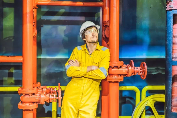 Mladík ve žluté pracovní uniformě, brýlích a helmě v průmyslovém prostředí, oleji Platforma nebo zkapalněný plyn — Stock fotografie
