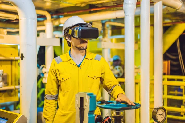 Mladá žena ve žluté pracovní uniformě, brýlích a helmě používá brýle virtuální reality v průmyslovém prostředí, ropné plošině nebo zařízení na zkapalněný plyn — Stock fotografie