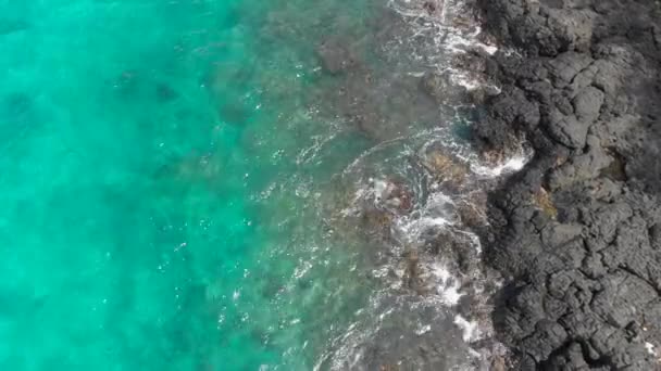 Vue aérienne d'une fantastique plage Blue Lagoon sur l'île de Bali avec une eau bleue cristalline et du sable blanc entouré d'incroyables roches volcaniques noires — Video