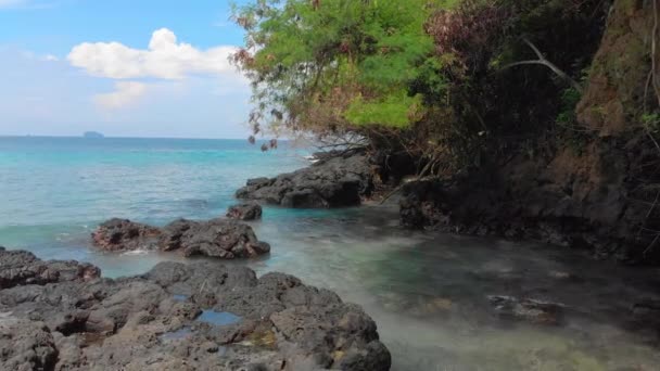 발리 섬의 환상적인 블루 라군 해변에서 수정처럼 맑은 푸른 물과 놀라운 검은 화산 암석으로 둘러싸인 하얀 모래를 공중 촬영합니다. — 비디오