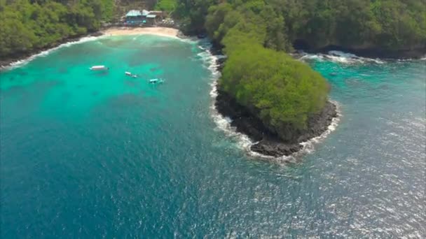 Fotografia aérea de uma fantástica praia da Lagoa Azul na ilha de Bali com uma água azul cristalina e areia branca cercada por incríveis rochas vulcânicas pretas — Vídeo de Stock