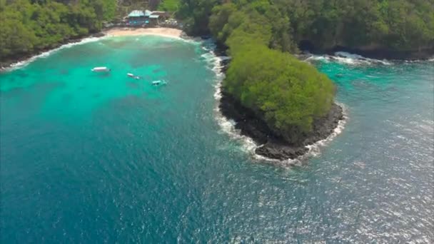 Aerial Shot av en fantastisk blå lagun strand på Bali Island med ett kristallklart blått vatten och vit sand omgiven av otroliga svarta vulkaniska klippor — Stockvideo