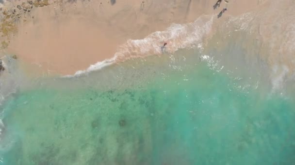 Fotografia aérea de uma fantástica praia da Lagoa Azul na ilha de Bali com uma água azul cristalina e areia branca cercada por incríveis rochas vulcânicas pretas — Vídeo de Stock