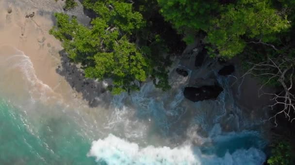 Lotnicze strzał fantastycznej plaży Blue Lagoon na wyspie Bali z krystalicznie czyste błękitną wodą i białym piaskiem otoczonym przez niesamowite czarne skały wulkaniczne — Wideo stockowe