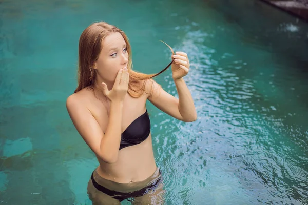 Gefrustreerde jonge vrouw met een slecht haar in het zwembad. Vanwege het feit dat chemicaliën in het zwembad — Stockfoto
