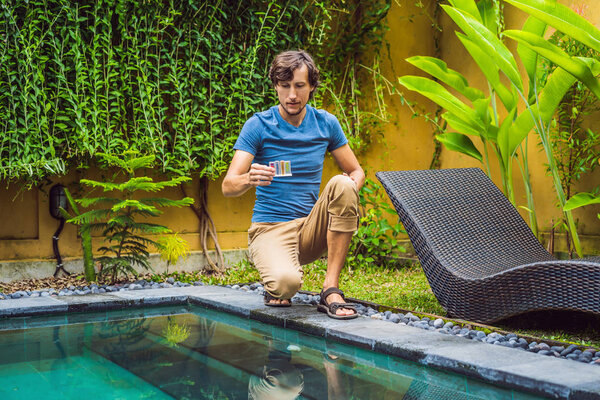 Работник бассейна проверяет бассейн на безопасность. Измерение хлора и рН бассейна
