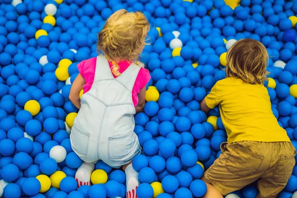 Gyerekek játszanak a labdát gödörbe. Színes játékok gyerekeknek. Óvoda vagy óvodai játszószoba. Totyogó gyerek nappali ellátás fedett játszótér. Labdák gyermekmedence. Aktív preschooler születésnapi partiján — Stock Fotó
