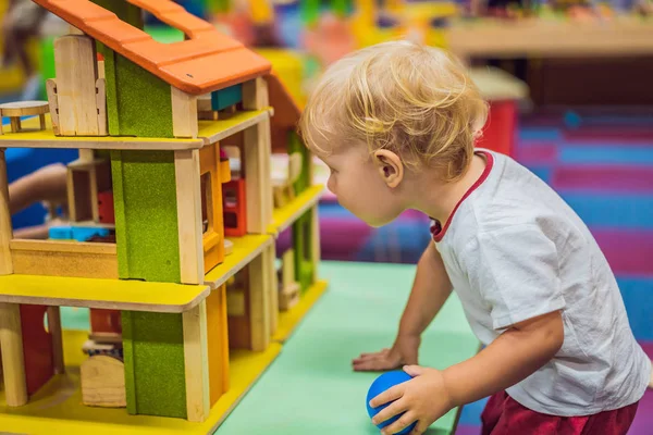 Chłopiec bawią się drewnianym domem z drewnianych kostek — Zdjęcie stockowe