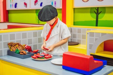 Çocuk oyuncak mutfakta oynuyor, pizza pişiriyor.