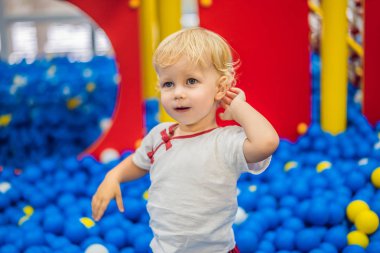 Çocuk top havuzunda oynuyor. Çocuklar için renkli oyuncaklar. Anaokulu ya da anaokulu oyun odası. Kreşteki küçük çocuk oyun parkında. Çocuklar için top havuzu. Aktif anaokulu öğrencisinin doğum günü partisi