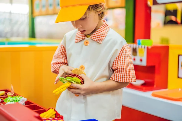 소년은 장난감 부엌에서 재생, 햄버거를 요리 — 스톡 사진
