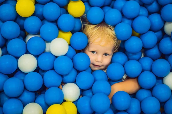 Child playing in ball pit. Colorful toys for kids. Kindergarten or preschool play room. Toddler kid at day care indoor playground. Balls pool for children. Birthday party for active preschooler — Stock Photo, Image