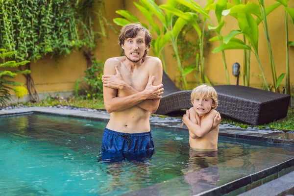 Ο μπαμπάς και ο γιος πάγωσαν στην πισίνα. Πολύ κρύο νερό στην πισίνα. Χρειάζεται θερμαινόμενο νερό — Φωτογραφία Αρχείου