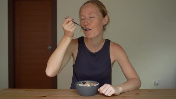 Nahaufnahme einer jungen Frau, die eine leckere und gesunde Smoothie-Schüssel isst — Stockvideo