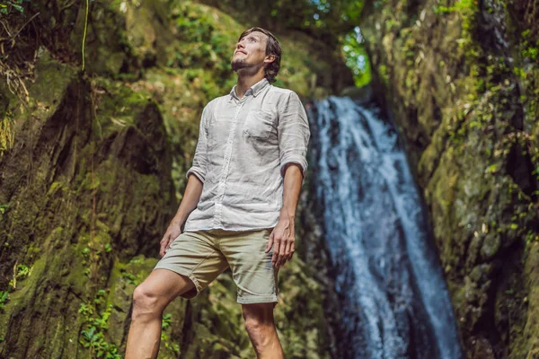Счастливый человек наслаждаясь удивительным тропическим водопадом поднял руки Путешествия стиль жизни и успешной концепции отдыха в дикой природе на фоне горы — стоковое фото