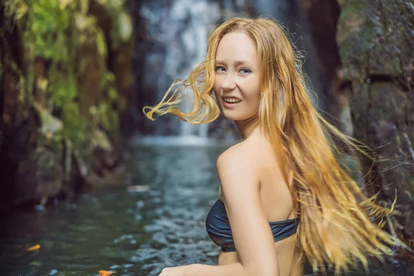 Młoda piękna kobieta stojąca w wodzie nad wodospadem — Zdjęcie stockowe