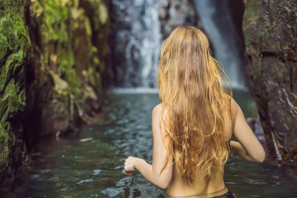 Young beautiful woman standing in the water at the waterfall — 스톡 사진