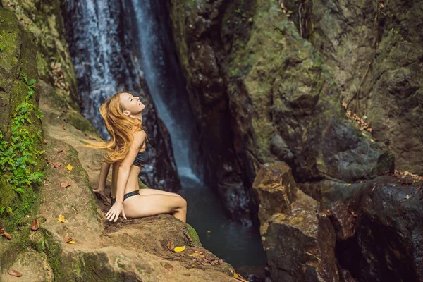 Junge schöne Frau steht im Wasser am Wasserfall — Stockfoto